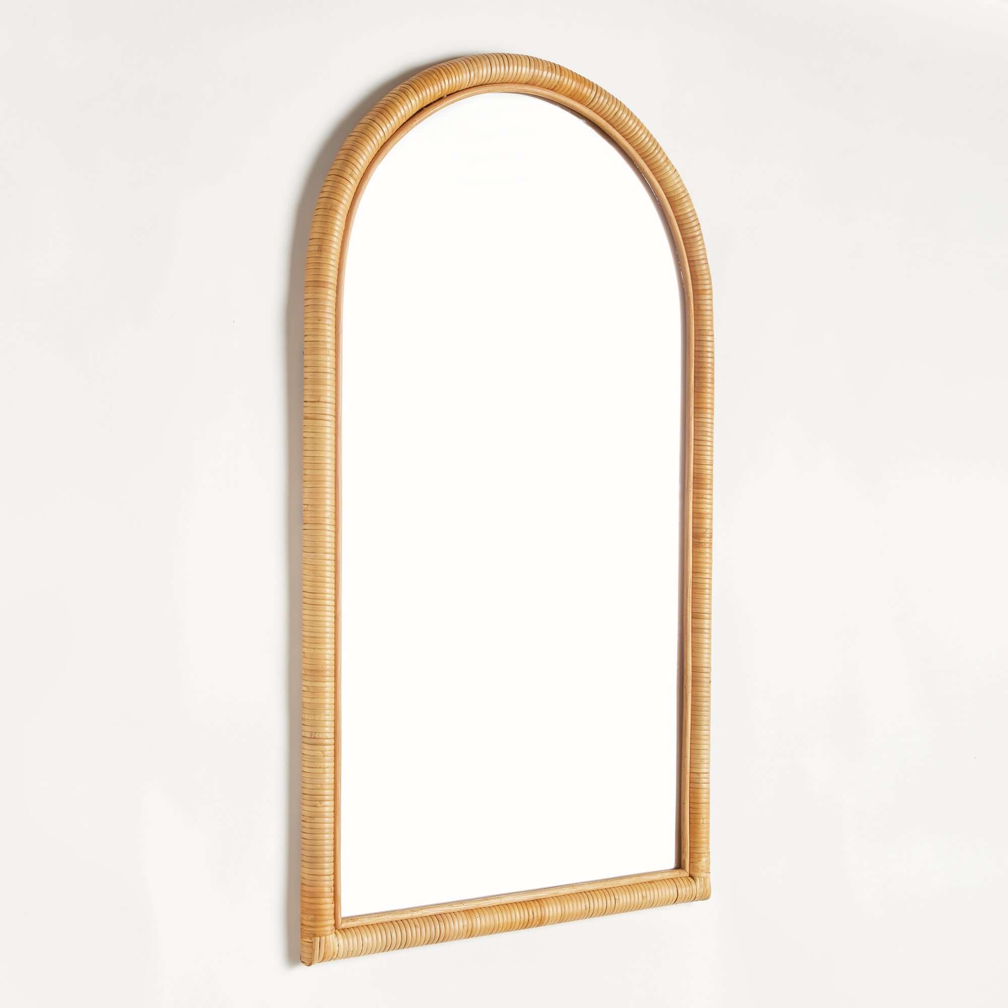 Arched mirror with wicker frame on a white background